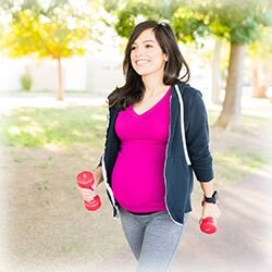 Photo of Pregnant Woman Walking with Dumbbells 