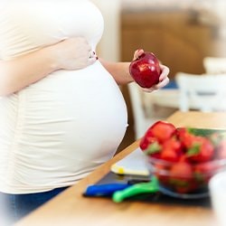 Image of a woman's pregnant belly and fruit