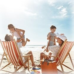 Photo of family having fun at the beach with their children