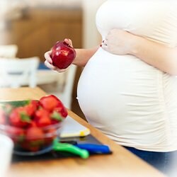 Picture of a woman's pregnancy and her holding fruit