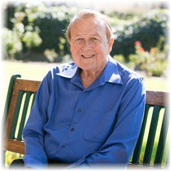 Photo of Bob Henderson sitting on a bench outdoors