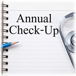 Photo of pencil and stethoscope placed over an open notebook with "Annual Checkup" written on a page