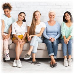 Photo of women of various ages sitting together on a couch