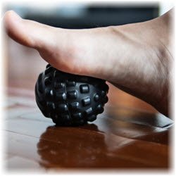 Photo of a bare foot rolling over a textured ball