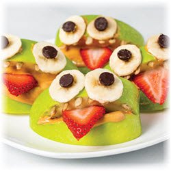 Photo of green apple slices decorated to look like monster mouths using banana slices and chocolate