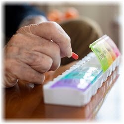 A senior organizing medication into a pill organizer