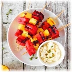 Grilled fruit kebabs on a round plate