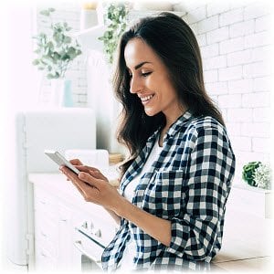 Photo of a woman at home browsing content on her mobile device