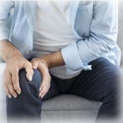 Photo of man holding his knee due to arthritis pain