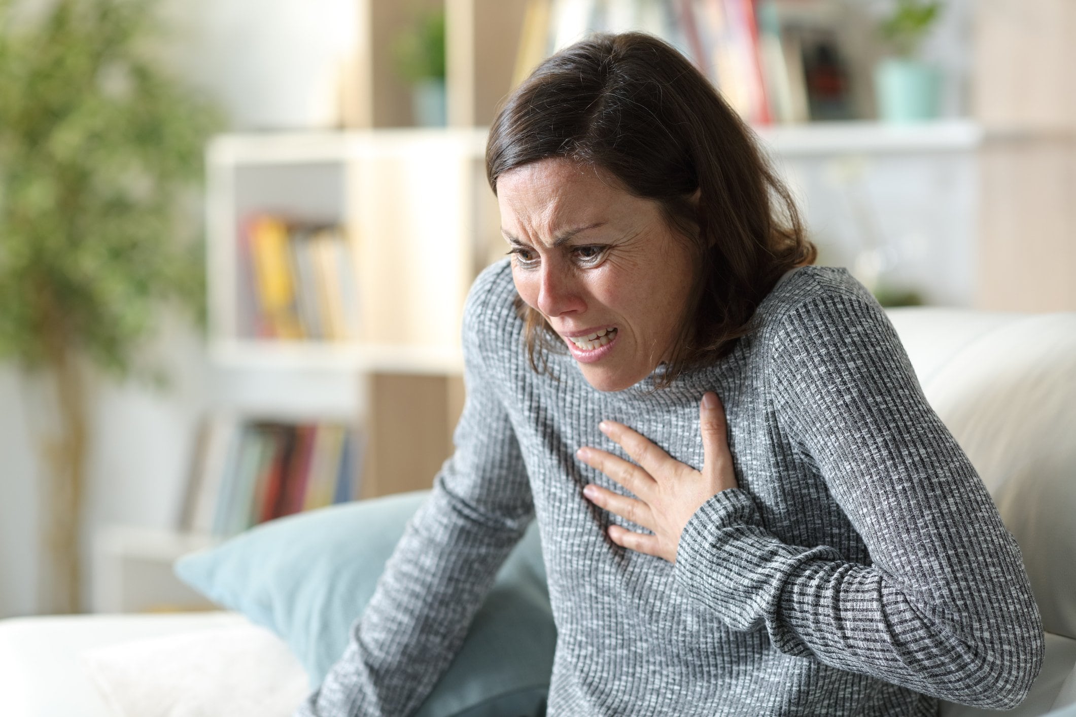 Photo of woman experiencing some pain in her chest and in distress