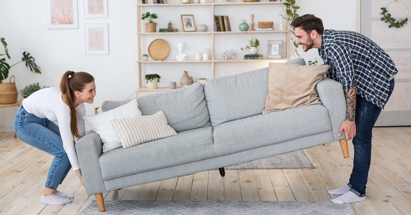 photo of couple carrying a couch