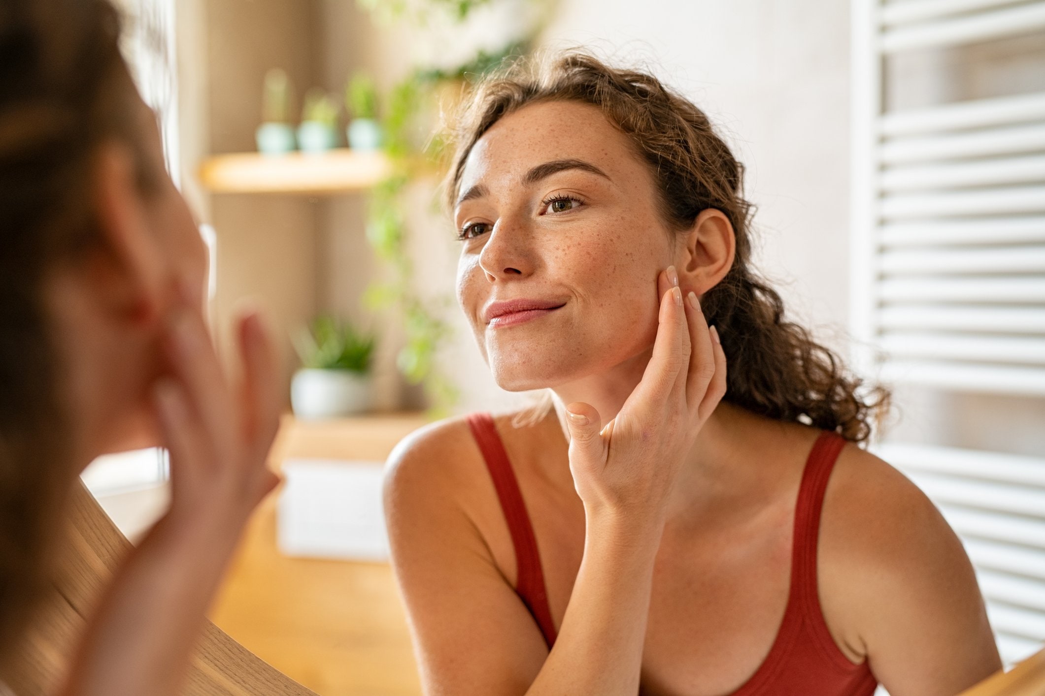 Photo of woman in front a mirror checking her skin