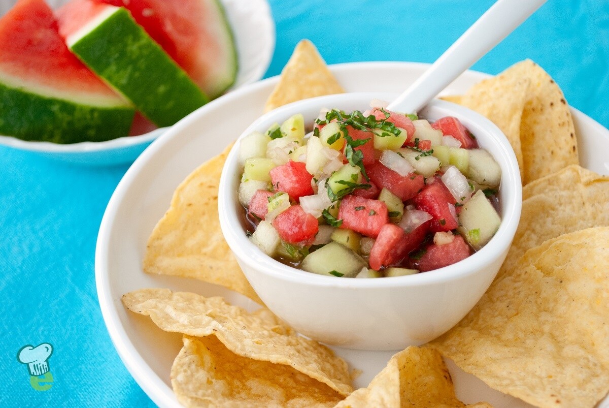 Picture of a bowl with watermelon salsa surrounded with chips on a plate