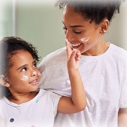 Photo of Mother and Daughter Moisturizing their face