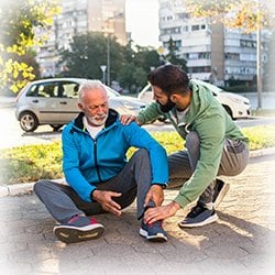 A man helping another man who has fallen down