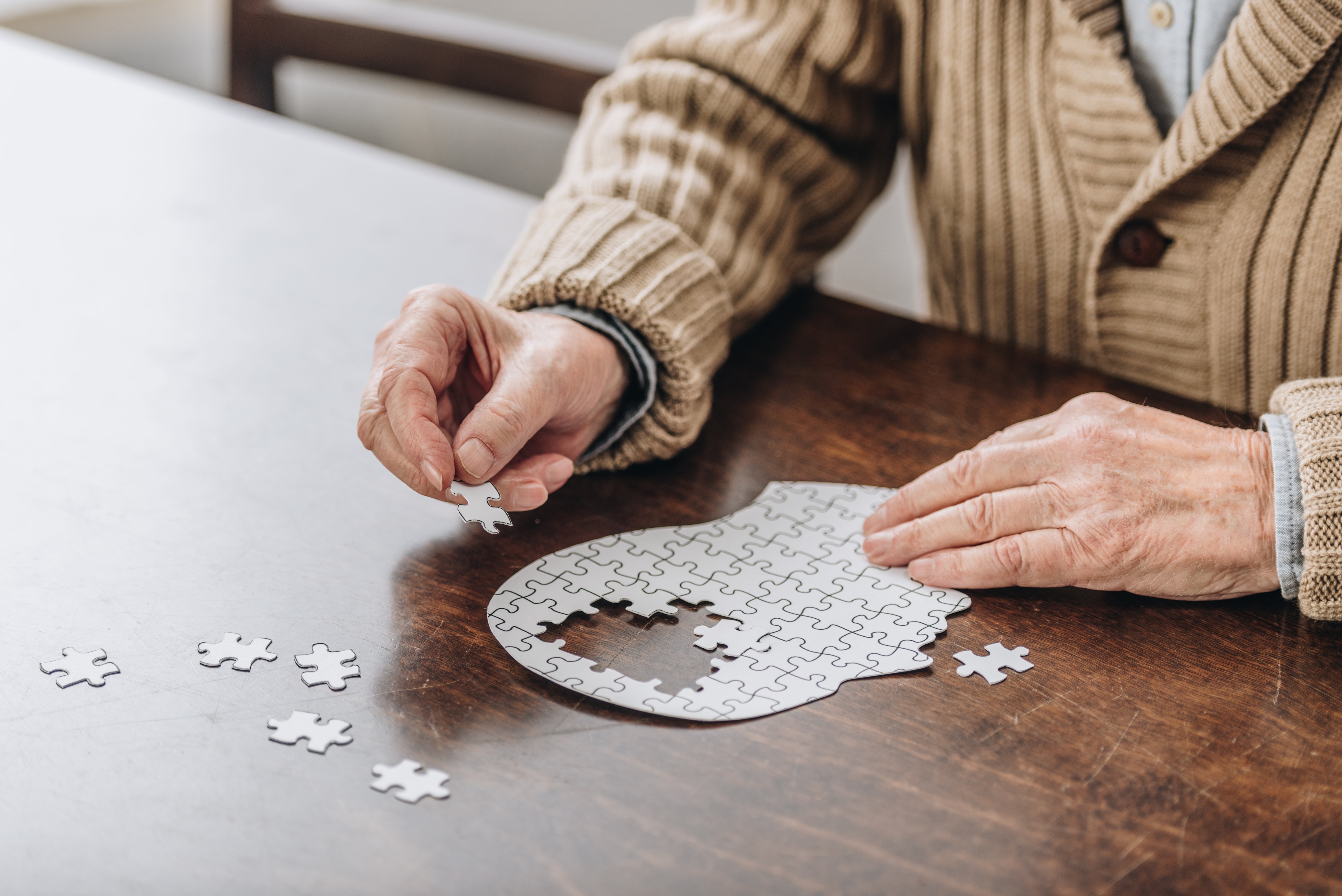 Photo of person sitting down at the table working on a puzzle