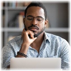 Photo of a man focused on reading something on his laptop