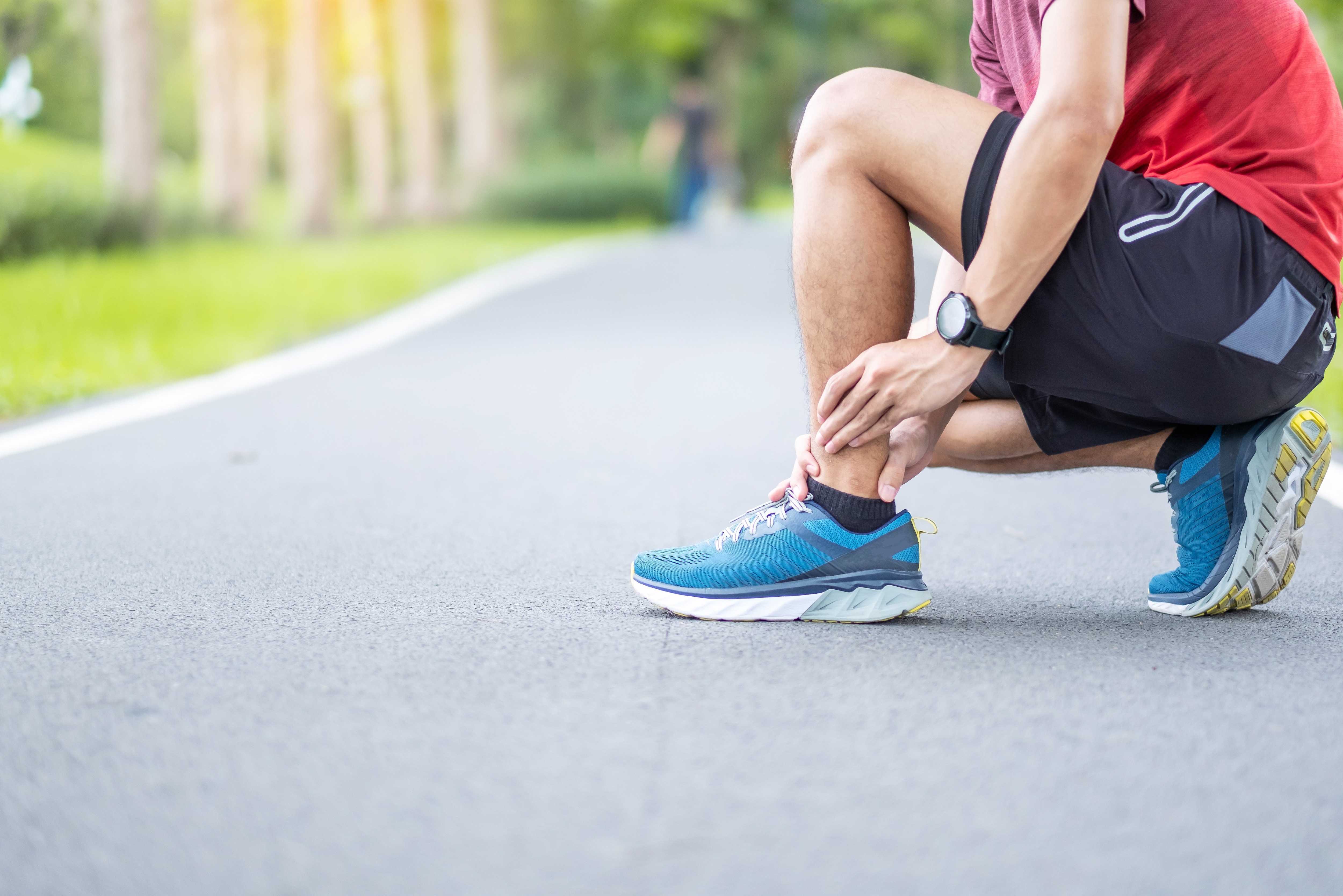 image of man holding his ankle