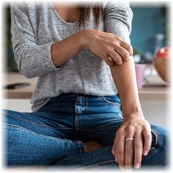 A woman scratching her arm