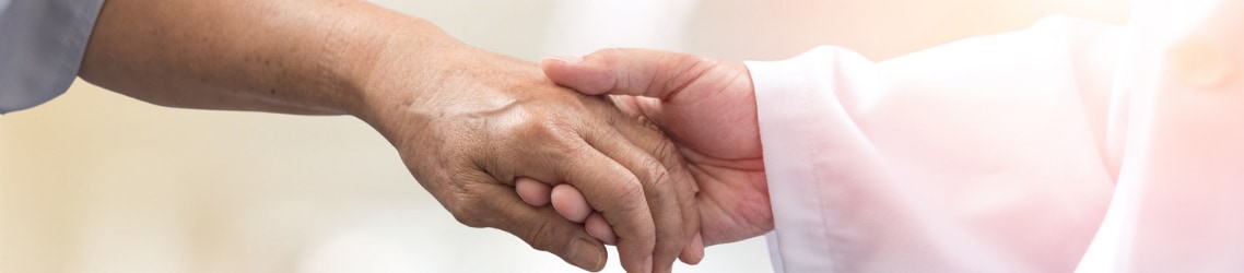 A doctor holding a patient's hand